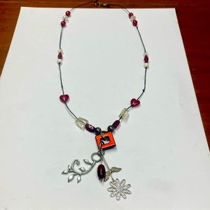 Handmade beaded and charmed necklace in red, white and silver. Original design